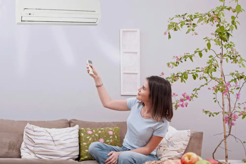 Mujer activando el funcionamiento del aire acondicionado